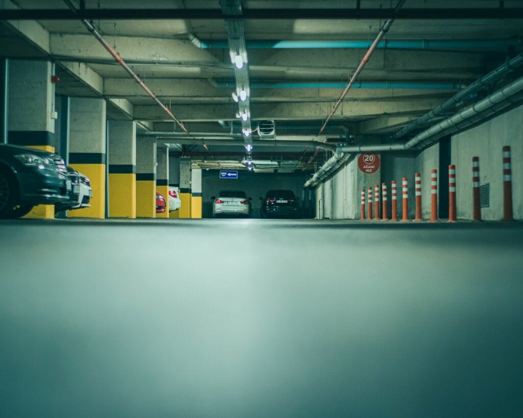 Plazas de un garaje comunitario con coches aparcados