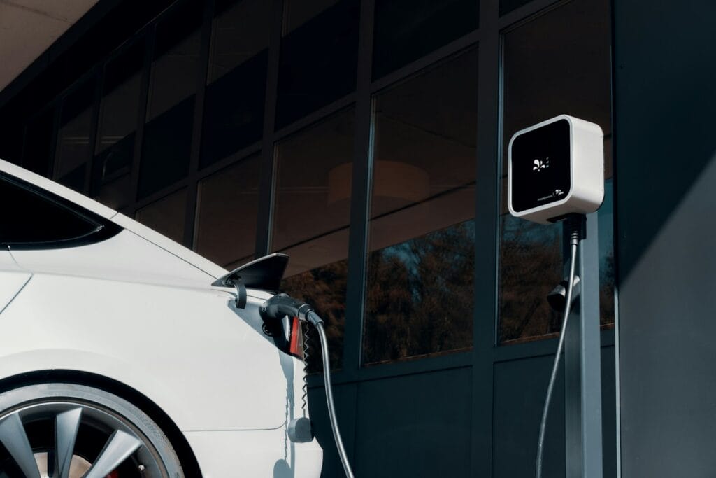 Coche eléctrico blanco conectado a un cargador
