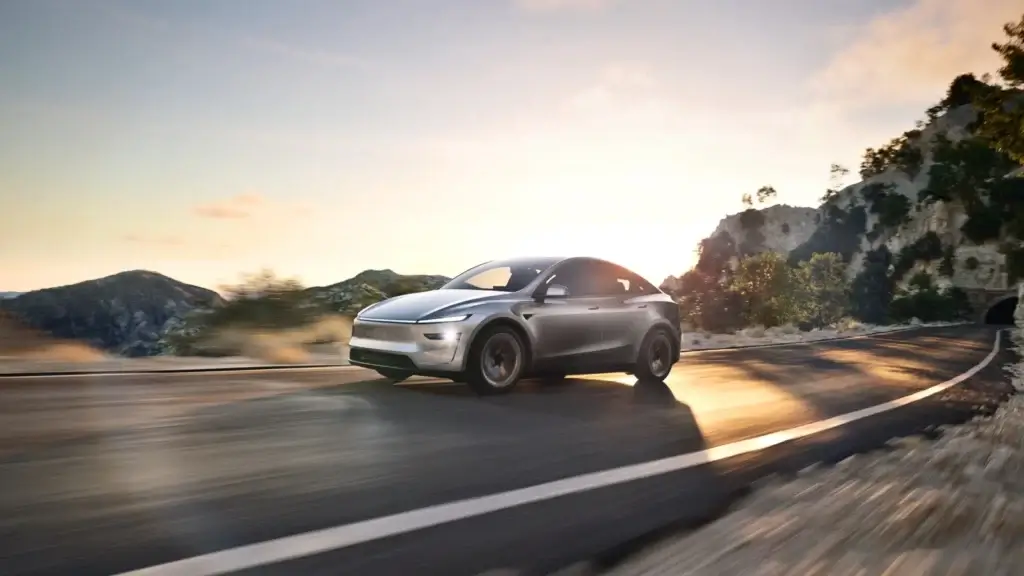 Tesla Model Y gris circulando por una carretera al atardecer